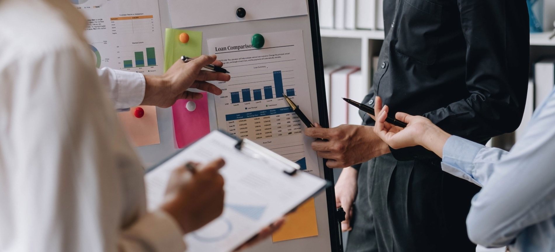 Un grupo de personas está de pie alrededor de una pizarra.