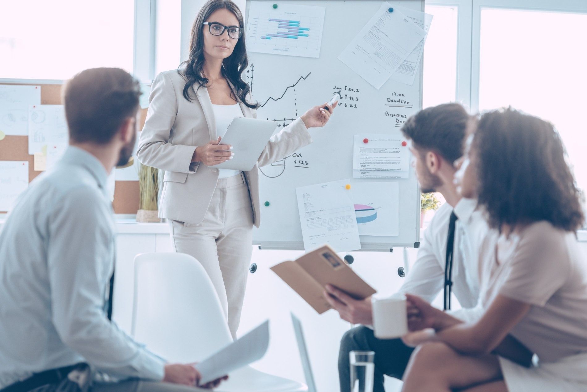 Una mujer está dando una presentación a un grupo de empresarios.